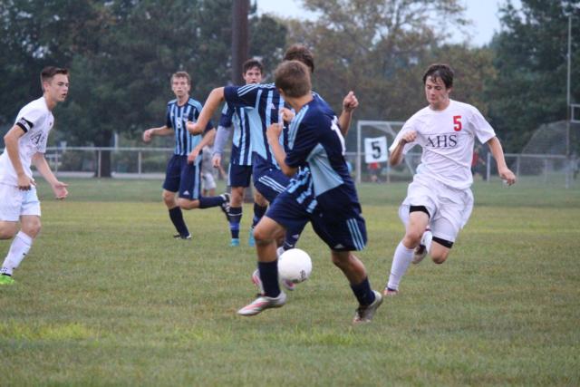 Junior midfielder CJ Nasello for Alton High School attempting to take the ball from his competitors. 